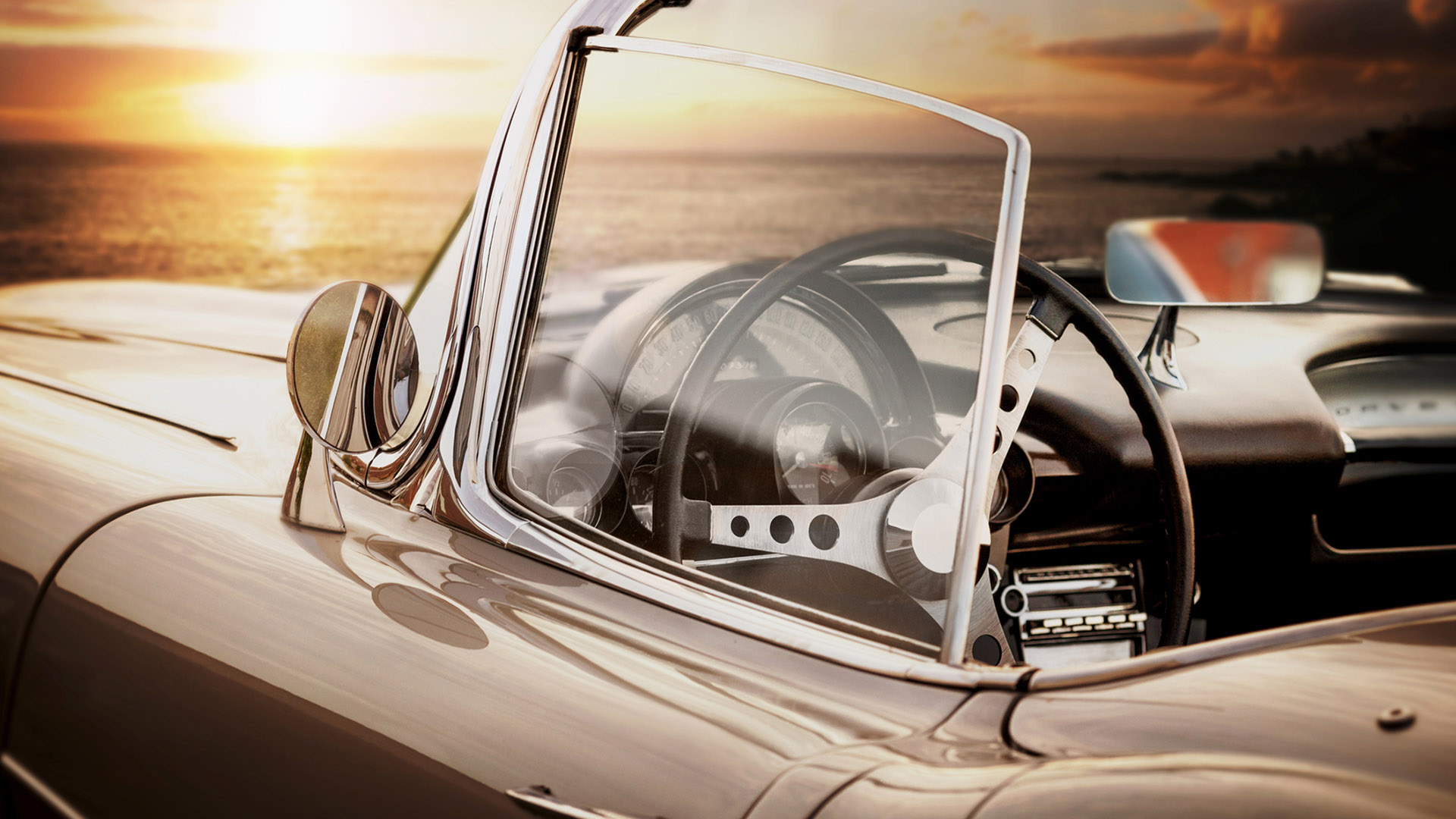 classic sports car parked over the ocean in california
